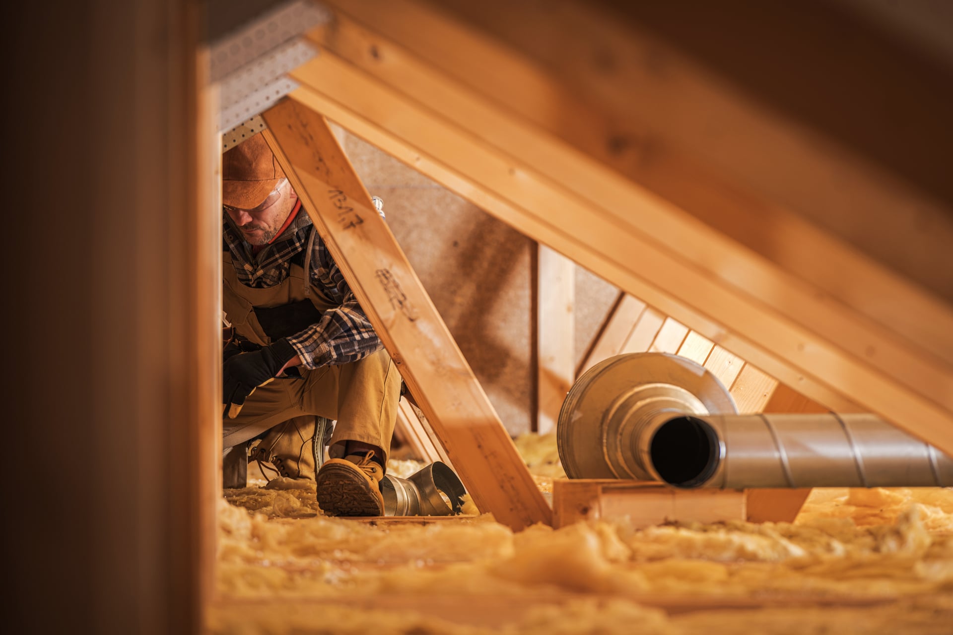 Technician working in attic with ductwork