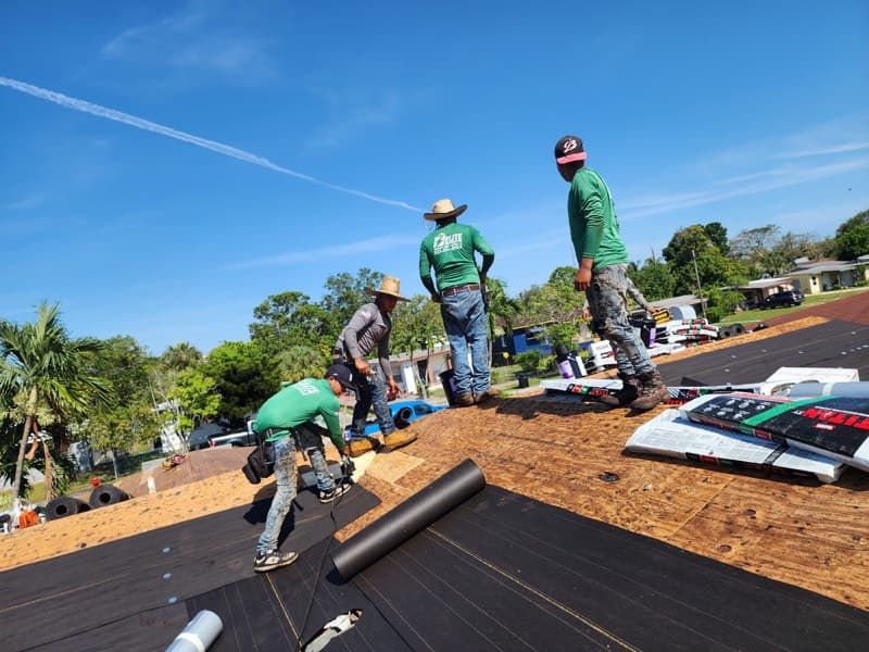 Roofing team installing underlayment after storm